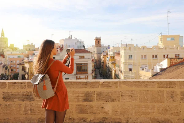 Visão traseira da menina viajante tirar fotos do terraço da paisagem urbana de Valência, Espanha . — Fotografia de Stock