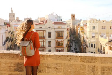 Visiting Valencia in Spain. Back view of young traveler woman enjoying cityscape of Valencia, Europe. clipart
