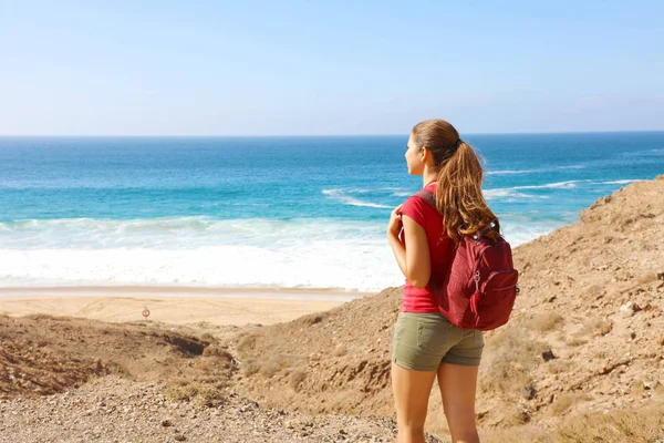 Kvinnlig vandrare backpacker njuter av utsikten över tom strand i Fuerteventura, Kanarieöarna — Stockfoto
