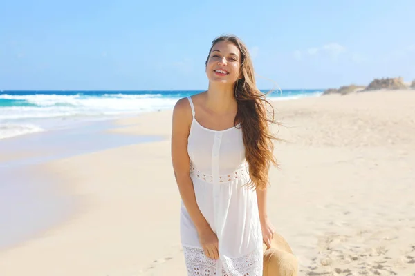 Portrét krásné usmívající se ženy s bílými slunečními šaty kráčející po písku v prázdné divoké pláži na Kanárských ostrovech — Stock fotografie