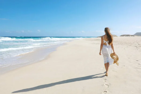 Νεαρή γυναίκα με τα πόδια σε άδεια άγρια παραλία με λευκή άμμο και γαλάζιο ουρανό, Corralejo, Κανάρια Νησιά — Φωτογραφία Αρχείου