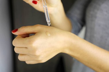 Female hands dropping serum collagen moisturizer. Protector skin clipart