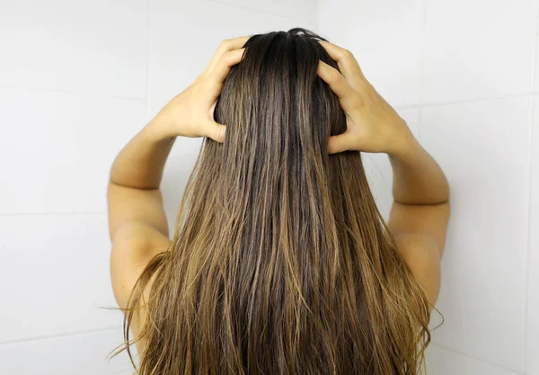 Mujer joven aplicando aceite para el cabello con los dedos. Cabello engrasado befo — Foto de Stock