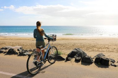 Playa Honda Sahili, Kanarya Adaları 'ndaki Atlantik Okyanusu manzarasının tadını çıkaran dişi motorcu.