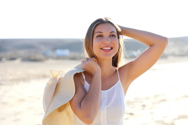 Jovem atraente se divertir na praia segurando grande chapéu de palha — Fotografia de Stock