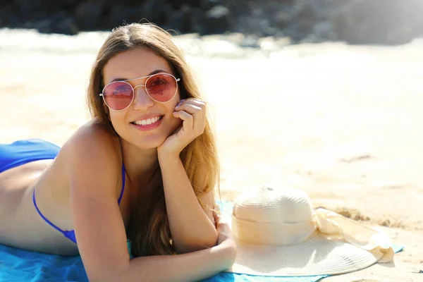 Jovem bela mulher sorridente desfrutando relaxar deitado na praia olhando para a câmera. Férias de verão conceito . — Fotografia de Stock