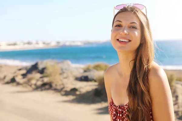 Pěkně usměvavá módní dívka radostný pohled na kameru venku. Šťastný smích krásná mladá žena hledá nadšený na kameru u oceánu moře na letní dovolenou. — Stock fotografie