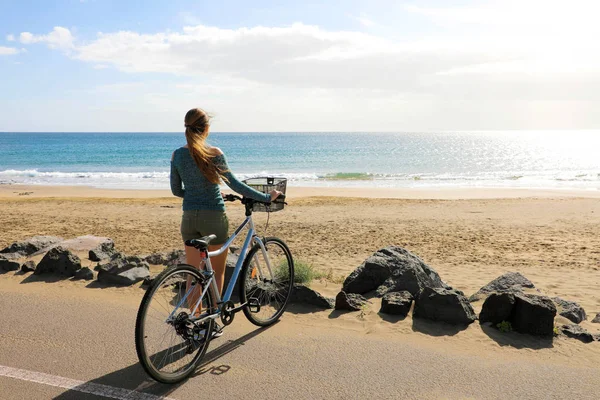 Achteraanzicht vrouwelijke biker genietend van uitzicht op de Atlantische Oceaan in Playa Honda strand, Canarische Eilanden — Stockfoto