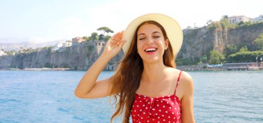 Yazlık şapkalı güzel bir kızın portresi. Sorrento panoramik pankarta sahip mutlu güzel kadın. Gülümseyen güzel kız Sorrento Sahili, İtalya 'da tatilin tadını çıkarıyor.