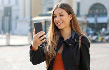 Video çağrısı. Şehirdeki internet araması için telefon kullanan transfer öğrenci..