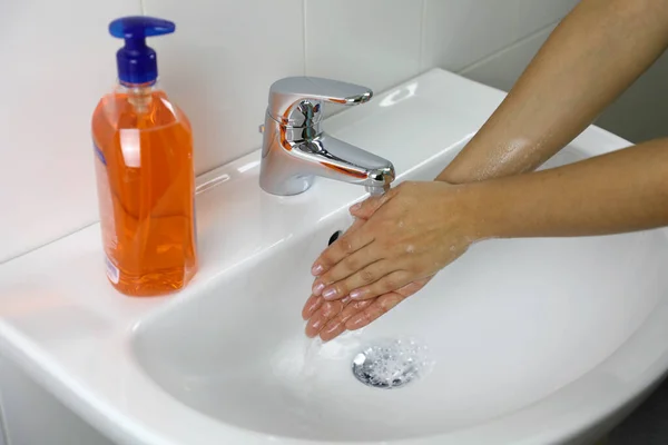 COVID-19 Hygiene concept. Washing hands with soap under the faucet with water against Novel coronavirus (2019-nCoV). Antiseptic, Hygiene and Healthcare concept.