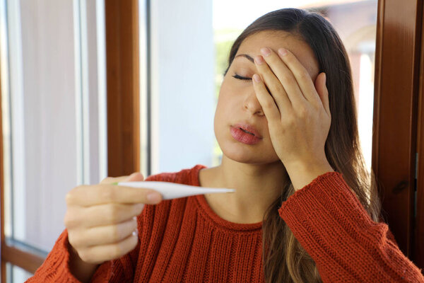 COVID-19 Pandemic Coronavirus Fever Sick Woman Checking Temperature Thermometer Symptoms SARS-CoV-2. Girl with symptom of Coronavirus Disease 2019 check fever.