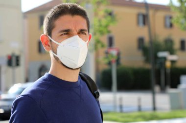 Coronavirus hastalığının yayılması için KN95 FFP2 yüz maskesi takan, şehirdeki COVID-19 Pandemic Coronavirus Man. SARS-CoV-2 'ye karşı yüz maskeli bir adam portresi.