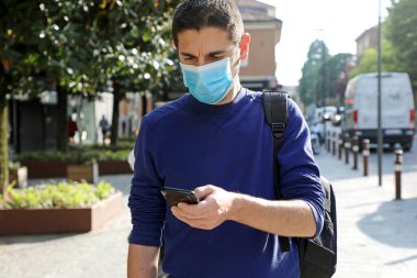 Coronavirus 2019 Coronavirus salgınına tepki olarak Şehir Sokağındaki Akıllı Telefon Uygulamasını kullanarak Temas İzleme ve Kişilik Tanılama Programı 'nı kullanan Endişeli Genç Adam.