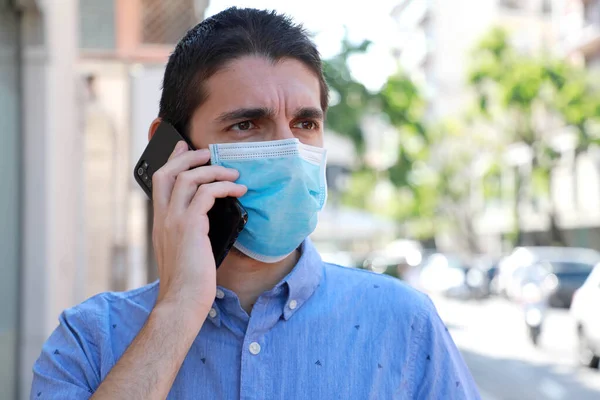 외과용 마스크를 착용하고 거리에서 전화로 전화하는 남자를 폐쇄하 — 스톡 사진