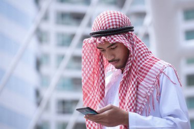 Arap işadamı kullanarak cep telefonu ve modern iş şehir 