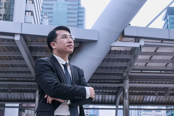 Vertrouwen Aziatische zakenman staande en kijken naar stad — Stockfoto