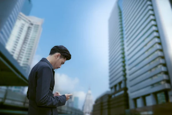 Aziatische business man staande en gebruik smartphone met bedrijf — Stockfoto