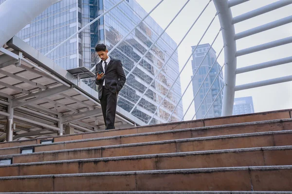 Hombre de negocios usando un teléfono celular y un moderno edificio de oficinas —  Fotos de Stock