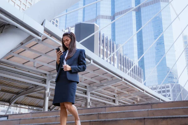Azjatycki biznes kobieta stojący i korzystanie smartphone z firmy — Zdjęcie stockowe