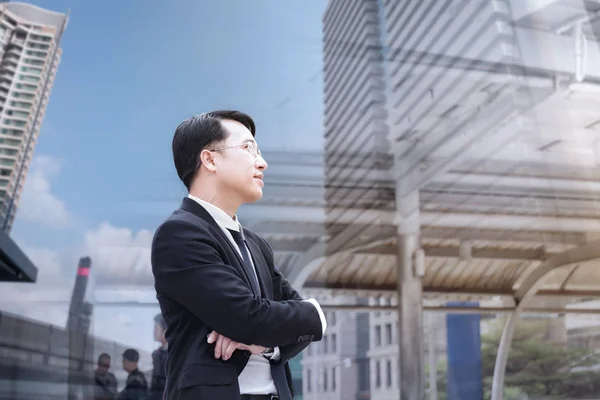 Pewni azjatycki biznes biznesmen stojąc i patrząc na miasto — Zdjęcie stockowe