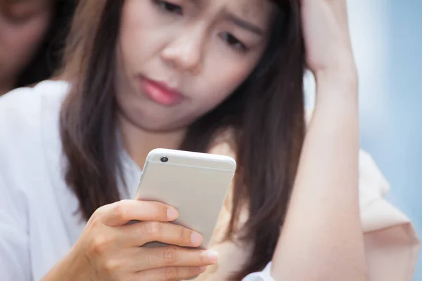 Азиатская деловая женщина, использующая сотовый смартфон и путать о плохом — стоковое фото