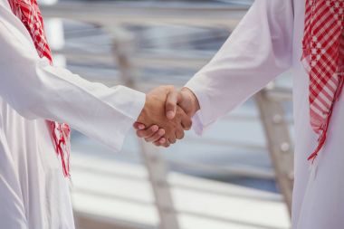iki Arap iş adamları elini sıkmak ve birlikte suc için tartışmak