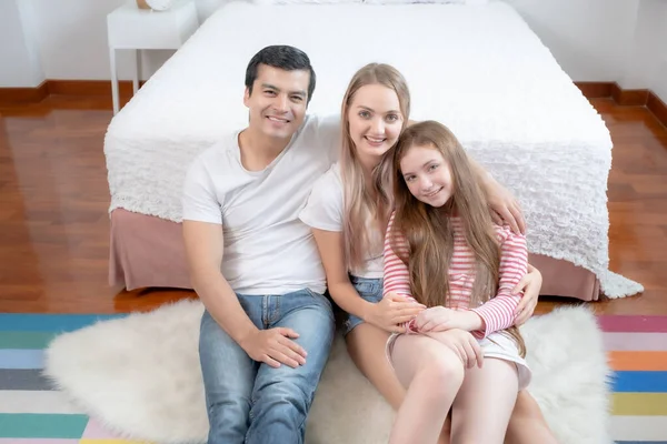 Bambina sorridente con madre e padre sul letto insieme in essere — Foto Stock
