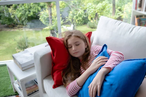 Bambina che dorme sul divano di casa per riposare, giovane fa felice — Foto Stock