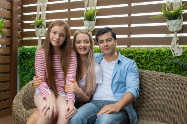 Mor, far och dotter sitter på soffan och stora leende toge — Stockfoto