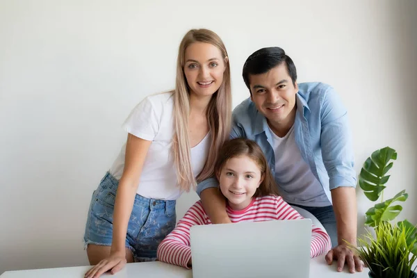 Madre, padre aconseja hija para el uso de ordenador portátil en casa — Foto de Stock