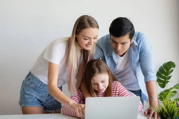 Madre, padre aconseja hija para el uso de ordenador portátil en casa —  Fotos de Stock