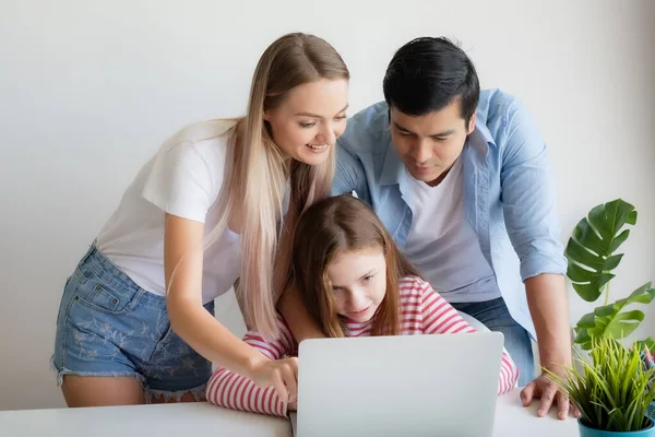 Madre, padre aconseja hija para el uso de ordenador portátil en casa — Foto de Stock