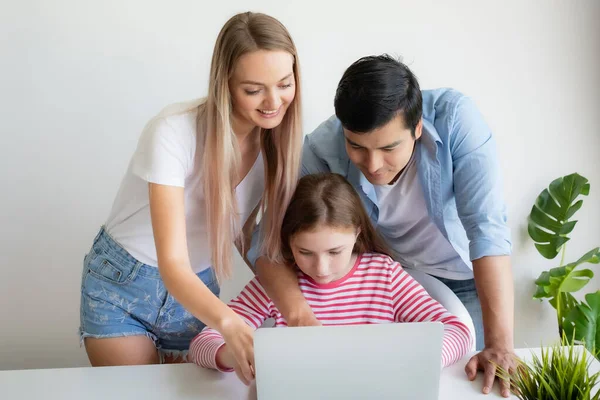 Μητέρα, πατέρας συμβουλεύει την κόρη για τη χρήση φορητού υπολογιστή στο σπίτι — Φωτογραφία Αρχείου