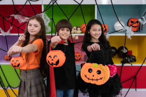 Gruppo di ragazza e ragazzo bambini vestire il costume e tenere la zucca — Foto Stock