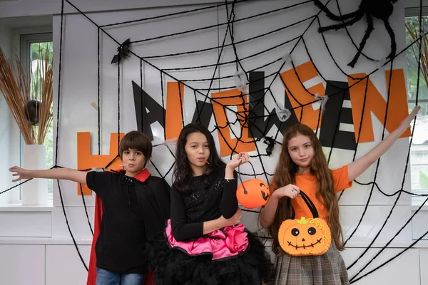 Gruppo di ragazza e ragazzo bambini vestire il costume e tenere la zucca — Foto Stock