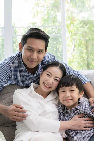 Asian family father, mother and son smiling together in living r