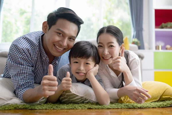 Asiatisk familj far, mor och son lägga sig på golvet och smilin — Stockfoto