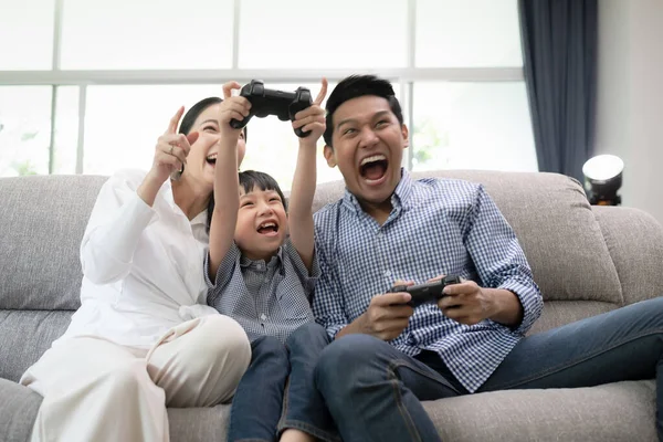 Familia joven, padre, madre e hijo viendo la televisión y jugando gam — Foto de Stock