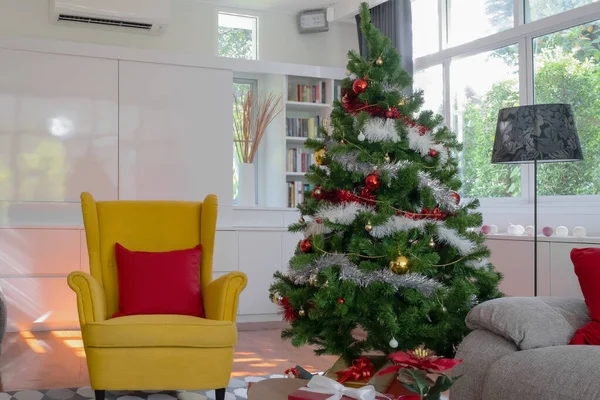 Grote gele stoel in woonkamer met kerstboom en cadeau pre — Stockfoto