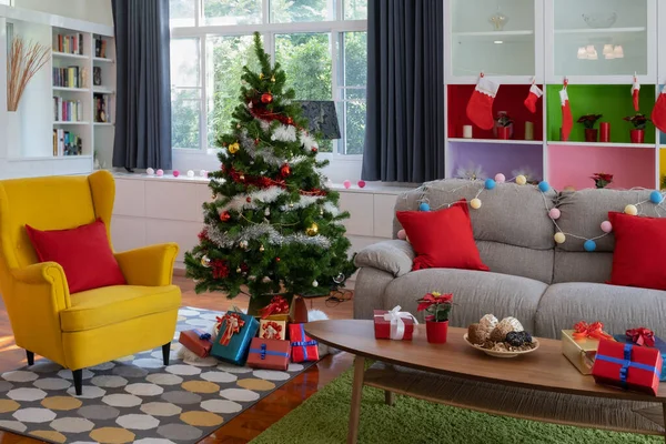Большой желтый стул в гостиной с елкой и подарком — стоковое фото