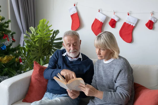 Anziano anziano caucasico vecchio e donna lettura del libro e sedersi — Foto Stock