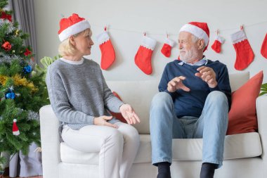 Yaşlı, beyaz, yaşlı bir adam ve kırmızı şapkalı bir kadın.