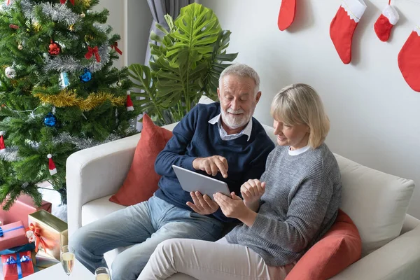 Senior oudere Kaukasische oude man en vrouw zitten op de bank, usin — Stockfoto