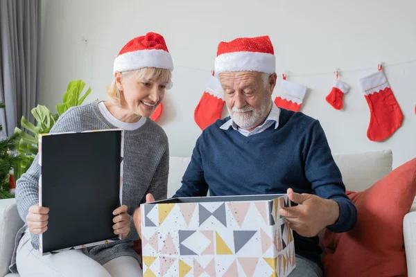 Idoso idoso caucasiano velho homem e mulher ajudar a abrir grande presente pr — Fotografia de Stock