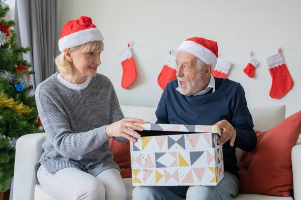 Senioren ouderen Kaukasische oude man en vrouw helpen openen grote gift pr — Stockfoto