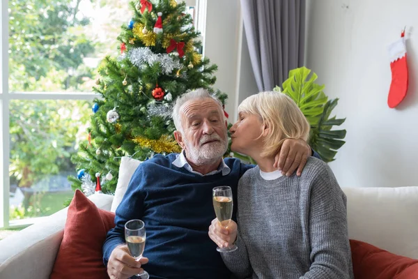 Idoso caucasiano velho mulher beijando homem segurando champanhe — Fotografia de Stock