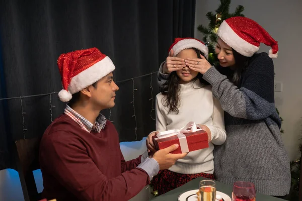 Счастливая семья, мать закрытые глаза дочери и отец дать подарок р — стоковое фото