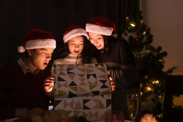 Lycklig familj, far mor dotter hjälp att öppna present b — Stockfoto