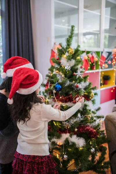 Terug uitzicht op moeder en dochter helpen om cadeau, speelgoed, pr versieren — Stockfoto